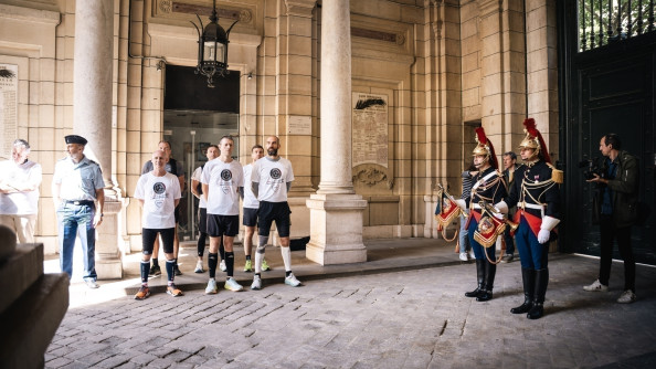 Photos de coureurs, debout, c&ocirc;te &agrave; c&ocirc;te, aux c&ocirc;t&eacute;s de garde r&eacute;publicains. Tous attendent debout sous un porche