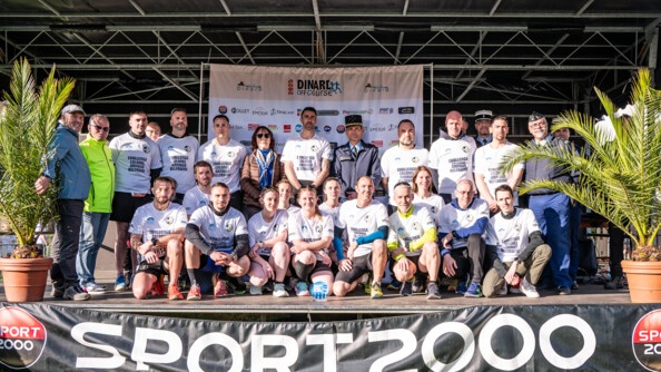 Photo d'un groupe de gendarmes, tous vêtus du même tshirt blanc, se tenant sur un podium, à l'arrivée d'une course