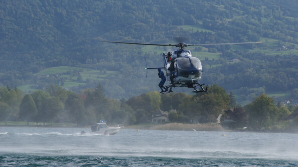 Au dessus du lac, un gendarme plongeur se prépare à sauter dans l'eau.