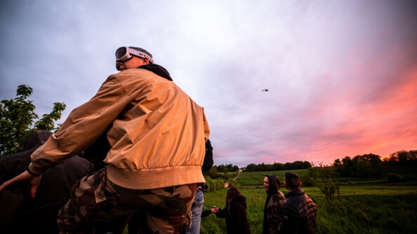 Un raver regarde l'hélicoptère de la gendarmerie avec un magnifique coucher de soleil