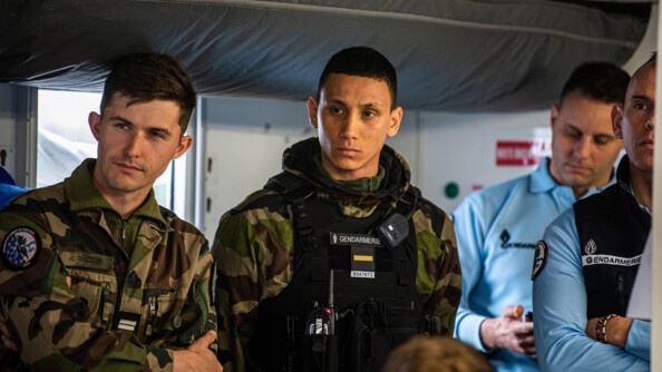 Officiers-élèves au premier plan dans le poste de commandemant pendant un briefing