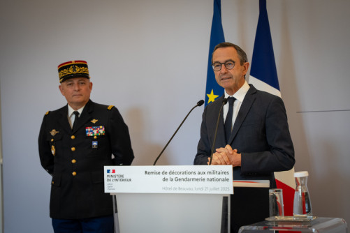 Bruno retailleau, ministre de l'Intérieur, prononce un discours devant un pupitre sr lequel est inscrit "Remise de décorations aux militaires de la Gendarmerie nationale". A ses côtés se tient le directeur général de la gendarmerie nationale.