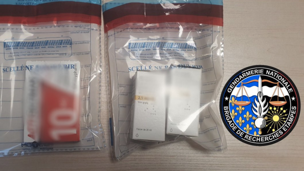 Deux poches transparentes contenant des boîtes de médicaments sont posées sur une table. Sur la droite de l'image, apparait un écusson portant la mention "Gendarmerie nationale - Brigade de recherches d'Etampes"r