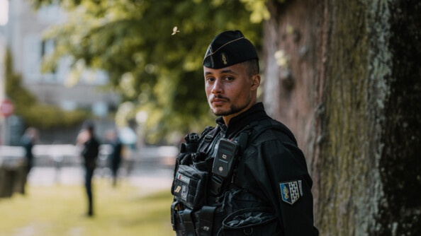 Un gendarme mobile et derrière, en flou, un parc.