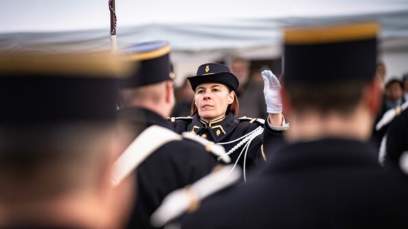 Les musiciens de la gendarmerie mobile de dos et en flou avec en fond et net la cheffe d'orchestre.