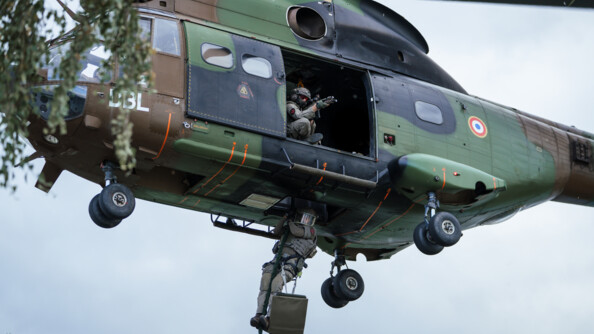 Un gendarme du GIGN descend en corde lisse depuis un Puma du GIH, tandis qu'un autre militaire embarqu&eacute;, arme en joue, l'appuie et s&eacute;curise sa descente.