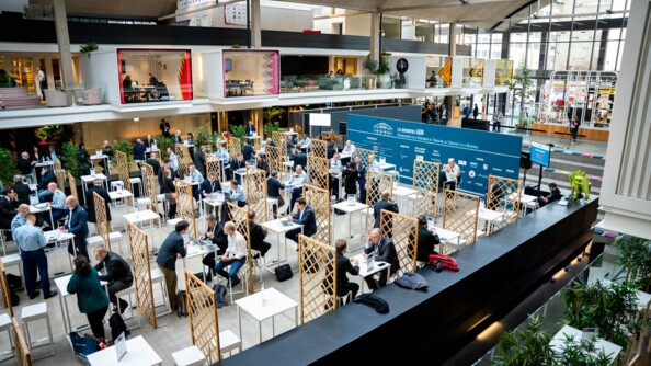 Dans la grande salle de la Station F, sous la grande verrière, des gendarmes, industriels et d'autres personnes échangent autour des speed-dating.