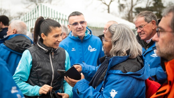 La lieutenante-colonelle Nassima Djelbi, porte-parole de la gendarmerie nationale, échange avec des membres de l'organisation de la Course du coeur, le jour du départ, mercredi 22 mars, au Bois de Boulogne, à Paris.