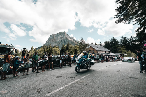 Un motocycliste de la gendarmerie sur la route salue le public.
