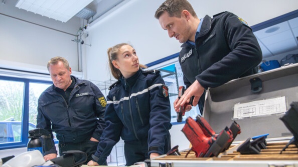 Une jeune gendarme écoute la présentation de l'arme de poing allemande
