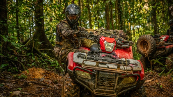 Militaire positionné sur un flanc du quad afin de l'empêcher de basculer.