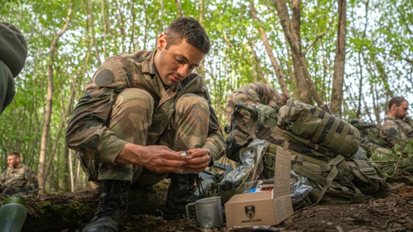 Un élève officier mange sa ration de combat le soir