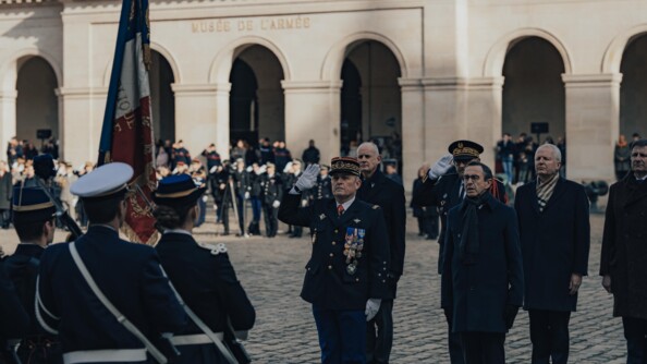 Le directeur général de la gendarmerie nationale et le ministre de l'intérieur devant le drapeau de la gendarmerie au cour d'une cérémonie de gendarmerie dans la cour pavée des invalides