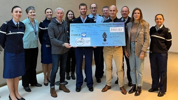 Dans l'angle d'une salle aux murs et sol clairs,un groupe de 15 personnes composés de gendarmes et de civils posent autour du chèque de 1000 euros remis à l'hôpital Necker suite à la participation des gendarmes à l'EcoTrail de Paris 2023
