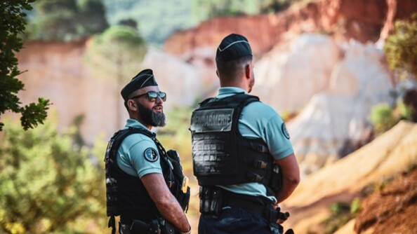 Deux gendarmes, l'un de dos, l'autre de trois-quart, dans les Ocres de Rustrel, dans le Vaucluse.
