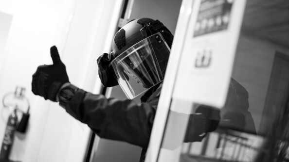 Photo en noir et blanc d'un gendarme du PSPG levant le pouce pour montrer que tout va bien.