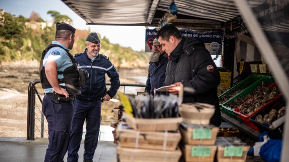 Deux gendarmes devant un stand de ventre d'huitres