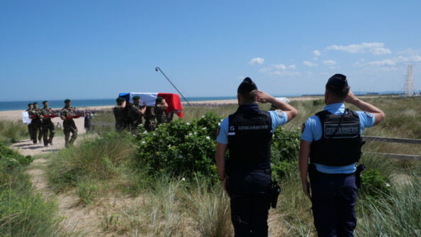 Deux gendarmes, de dos, saluent militairement le cercueil de Léon Gautier, recouvert du drapeau français.