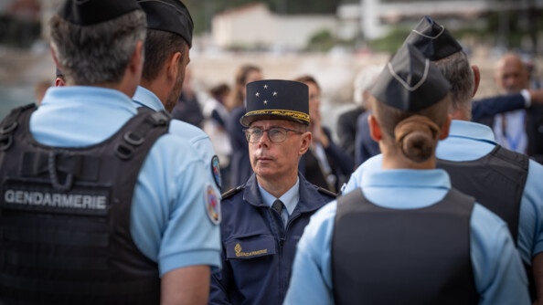 Le Major G&eacute;n&eacute;ral de la Gendarmerie Nationale &eacute;change avec des gendarmes se tenant debout face au g&eacute;n&eacute;ral. Tous portent un polo bleu ciel et un gilet pare balles noir.