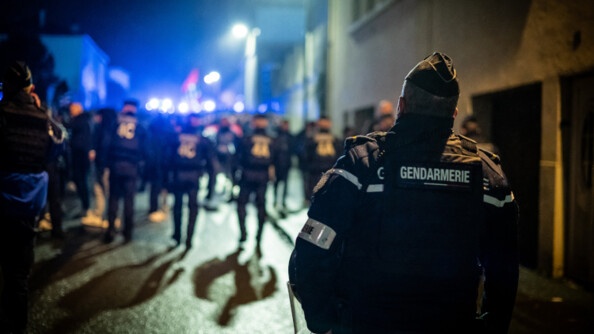 Gendarme de dos avec rangée de CRS devant.