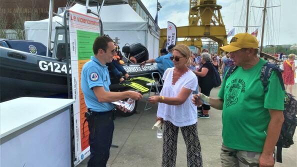 Un gendarme donne des prospectus &agrave; des visiteurs