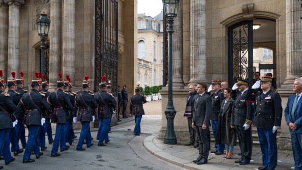 Militaires de la Garde républicaine pénétrant dans la cour de l'Elysée. A la droite de l'entrée se tiennent le chef de l'Etat ainsi que des personnalités officielles