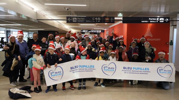 Les enfants de l'association à l'aéroport avec une banderolle.
