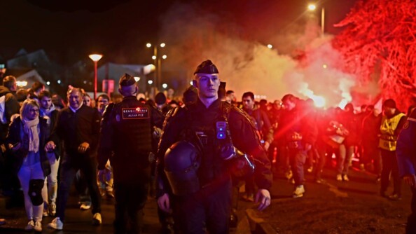 Gendarme mobile de face avec la foule en arrière plan.