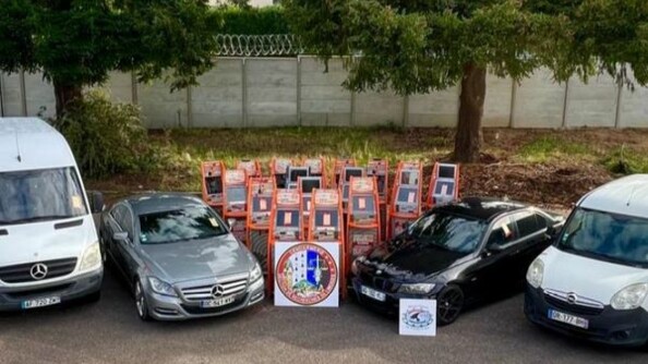 Au centre de l'image, 17 machines à sous sous scellé disposées en triangle inversé. Devant elles, la rondache de la section de recherches de Limoges. A gauche, une berline mercedes blanches et une camionnette mercedes blanche. A droite, une berline noire et un petit utilitaire opel blanc. En arrière-plan une bande terre herbeuse et deux arbres devant un muret gris