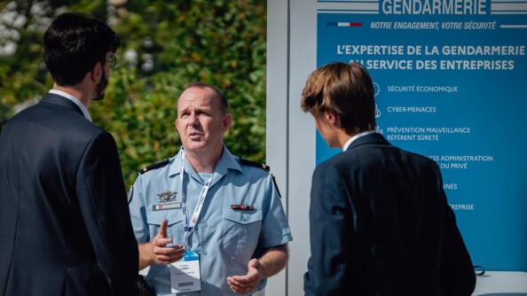 Gendarme échangeant avec des participants de la 6e édition de la Rencontre des entrepreneurs de France (REF) à l’hippodrome Paris-Longchamp.