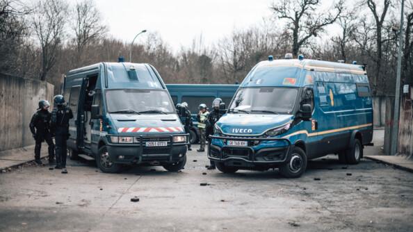 Vue de face d'un Irisbus et d'un véhicule de maintien de l'ordre à St Astier