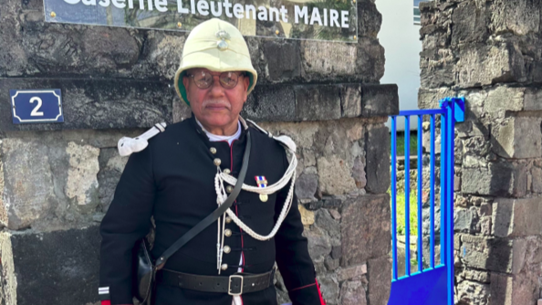 Un acteur en costume d'époque devant la plaque commémorative "caserne lieutenant maire"