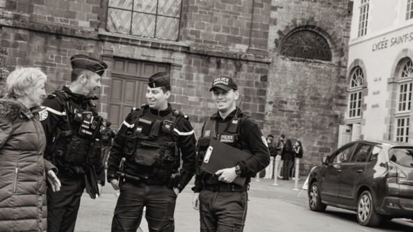 Photo prise lors d'une maraude. 2 gendarmes et un policier entrain de discuter avec une personne agée. Ils sourient.