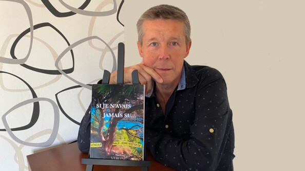 Photo de l'auteur avec devant lui, sur un chevalet noir, son livre sur lequel on aperçoit le tite "si je n'avais jamais su..."