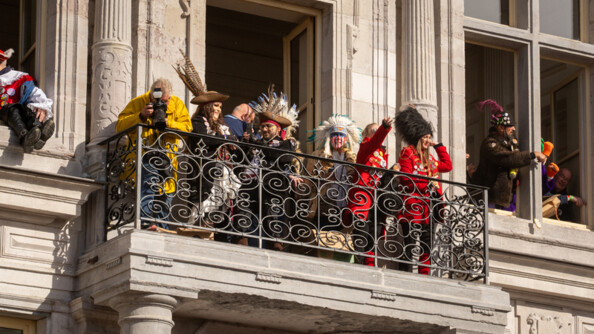 Photo de carnavaleux d&eacute;guis&eacute;s au balcon de l'H&ocirc;tel de ville de Bergues. la m&eacute;t&eacute;o est ensoleill&eacute;e.
