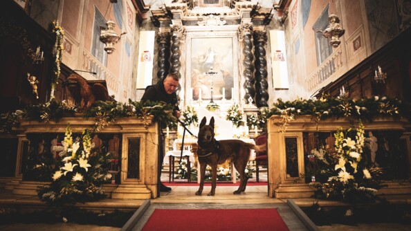 Chien spécialisé en explosifs avec son maître dans une église.