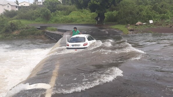 Un v&eacute;hicule et son conducteur pris dans un cours d'eau en crue sur l'&icirc;le de La R&eacute;union.