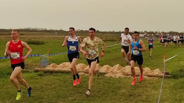 Passage d'obstacle par les coureurs sous un ciel coloré en orangé par le sirocco.