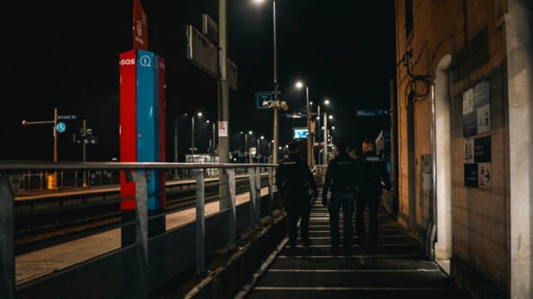 Trois gendarmes patrouillent dans une gare. Il fait nuit et sombre.