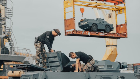 Trois gendarmes mobiles sur un VBRG tandis qu'en arri&egrave;re plan unautre VBRG est decendu dans une grue