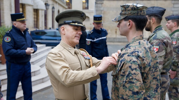 Un officier des Marines remet à un subordonné un brevet sur sa veste