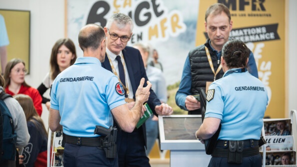 Deux gendarmes de dos sont entrain de parler avec deux agriculteurs.