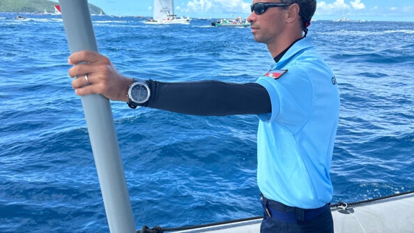 Au premier plan un gendarme en bateau surveille la régate. Au second plan, une yole et des bateaux à moteur.