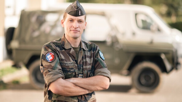 Le lieutenant-colonel Galaud se tenant bras croisés devant un véhicule type P4.