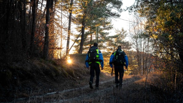 Deux gendarmes de la brigade enqu&ecirc;te environnement de dos marchent sur un chemin