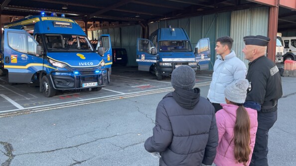 Les deux enfants se tenant devant les nouveaux véhicules de la gendarmerie mobile.