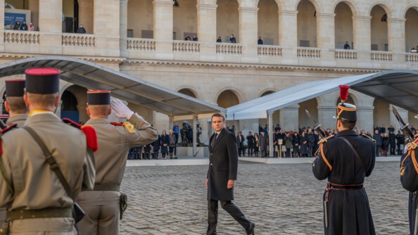 Le président de la république marche dans la cour face aux militaires qui le salut