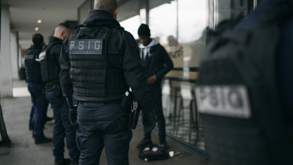 Quatre gendarmes procèdent au contrôle d'un piéton au pied de batiment