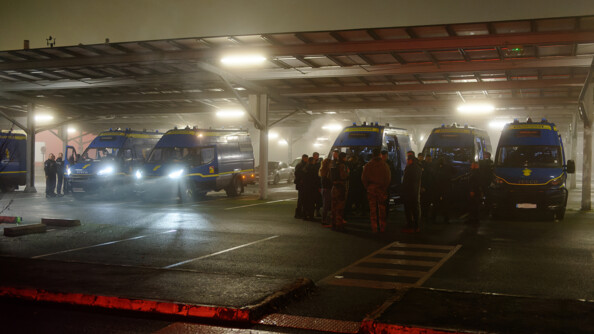 Une vingtaine de gendarmes sont regroup&eacute;s dans un parking. Il fait nuit. Ils se trouvent devant 6 camions de gendarmerie.
