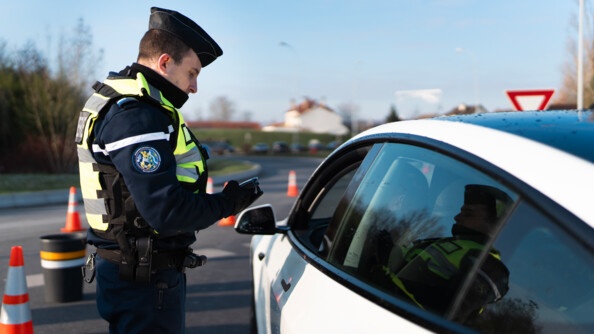 Un gendarme contrôle un véhciule blanc